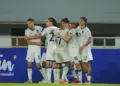 pemain sepak bola (mewakili Timnas Indonesia U-22) merayakan gol/kemenangan, menunjukkan euforia yang diharapkan dalam pertandingan.