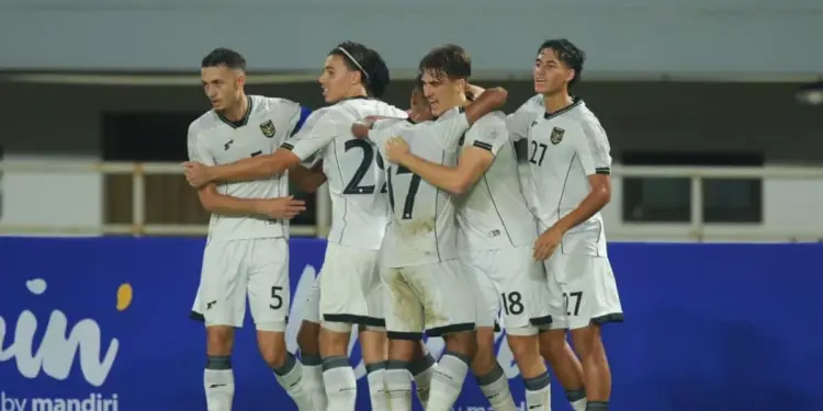 pemain sepak bola (mewakili Timnas Indonesia U-22) merayakan gol/kemenangan, menunjukkan euforia yang diharapkan dalam pertandingan.