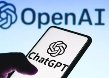 Logo ChatGPT di layar smartphone dengan logo OpenAI di latar belakang, mengilustrasikan studi tentang cara orang memakai ChatGPT.