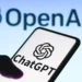 Logo ChatGPT di layar smartphone dengan logo OpenAI di latar belakang, mengilustrasikan studi tentang cara orang memakai ChatGPT.