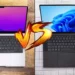 Perbandingan laptop Macbook vs Windows, menampilkan Macbook di sisi kiri dan laptop Windows 11 di sisi kanan dengan logo VS di tengah, untuk artikel investasi jangka panjang.
