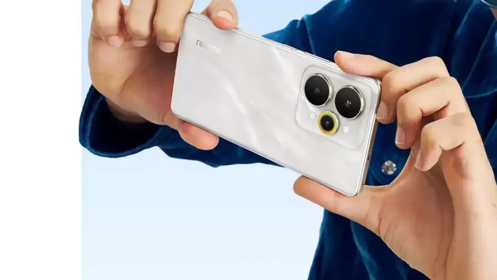 Seseorang sedang memegang HP Realme 15 Lite berwarna putih secara horizontal, menyoroti modul kamera belakang dengan sensor Sony OIS.