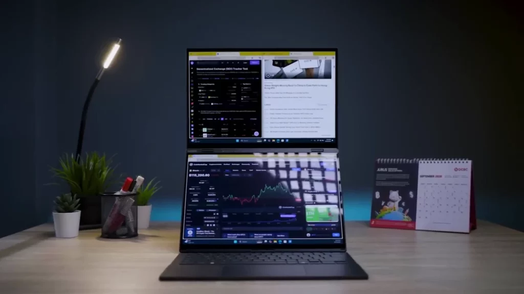 ASUS Zenbook DUO dalam mode dua layar vertikal, menampilkan grafik trading di layar bawah dan referensi berita di layar atas untuk produktivitas maksimal.