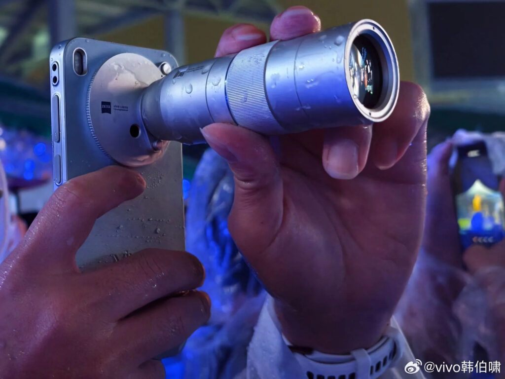 Tampilan penggunaan nyata lensa teleconverter Zeiss warna silver yang terpasang pada salah satu smartphone vivo X300 series.