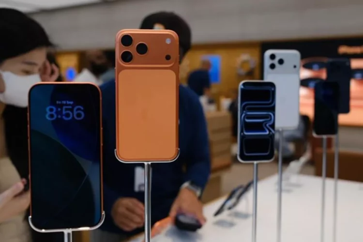 iPhone 17 (warna oranye) dan model lainnya dipajang di toko retail (iBox), dikelilingi oleh konsumen.