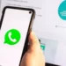 Logo aplikasi WhatsApp berwarna hijau ditampilkan di layar smartphone Android yang sedang dipegang.