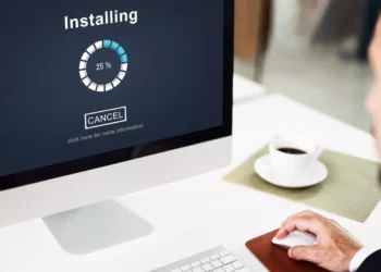 Proses instalasi atau update Pengaturan Windows berjalan 25% di layar monitor, dengan tombol "Cancel" dan seorang pengguna di sampingnya