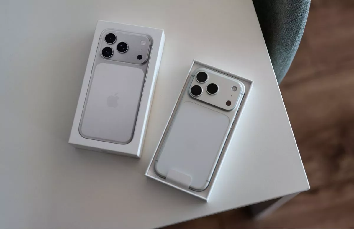 Dua kotak iPhone 17 Pro Max (model putih) yang baru dibuka, diletakkan di atas meja.