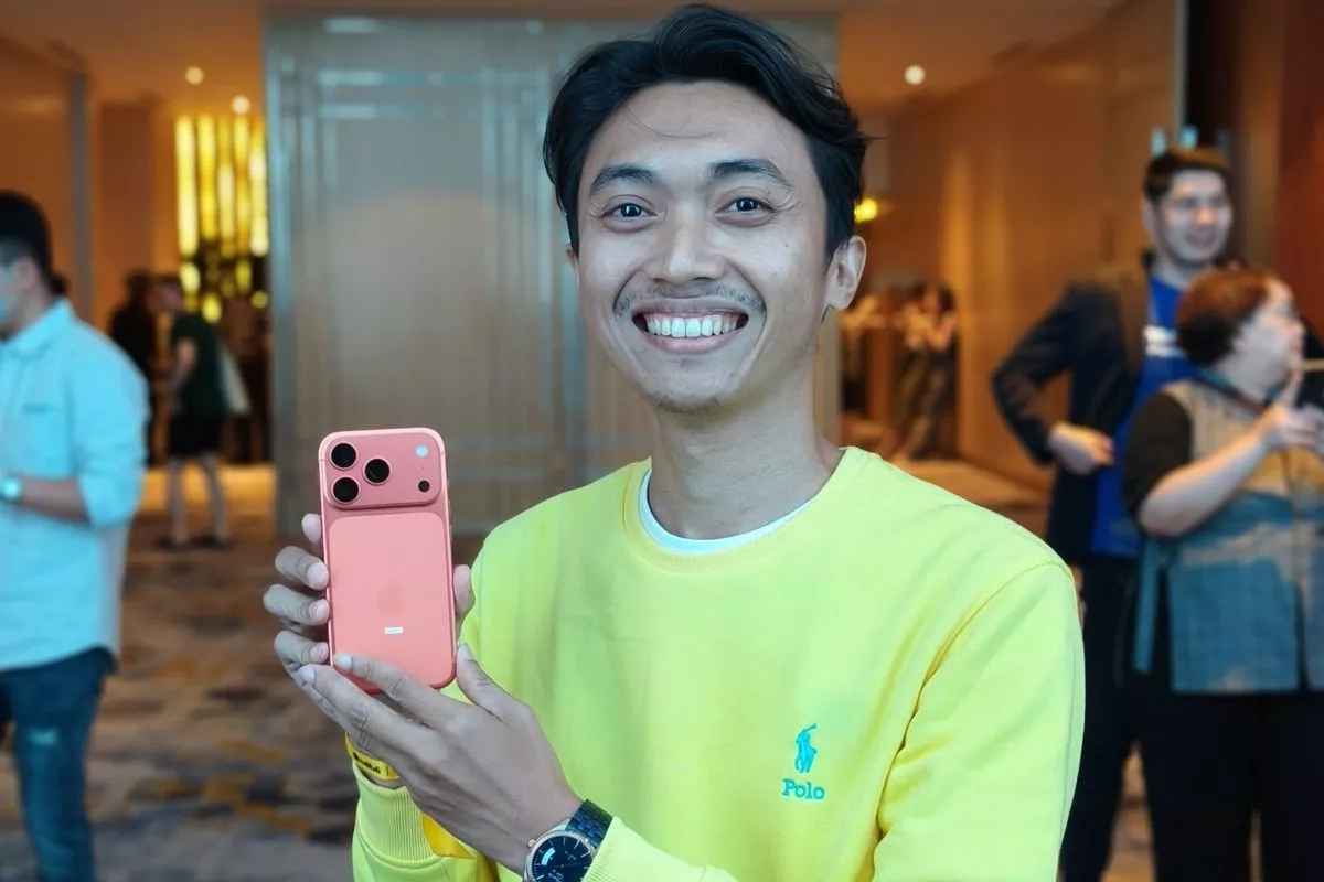 Seorang pria dengan kaus biru berbicara di panggung utama acara Blibli Midnight Launch iPhone 17 Pro.