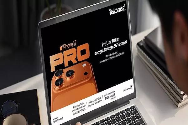 Pria melihat iklan iPhone 17 Pro Telkomsel di layar laptop