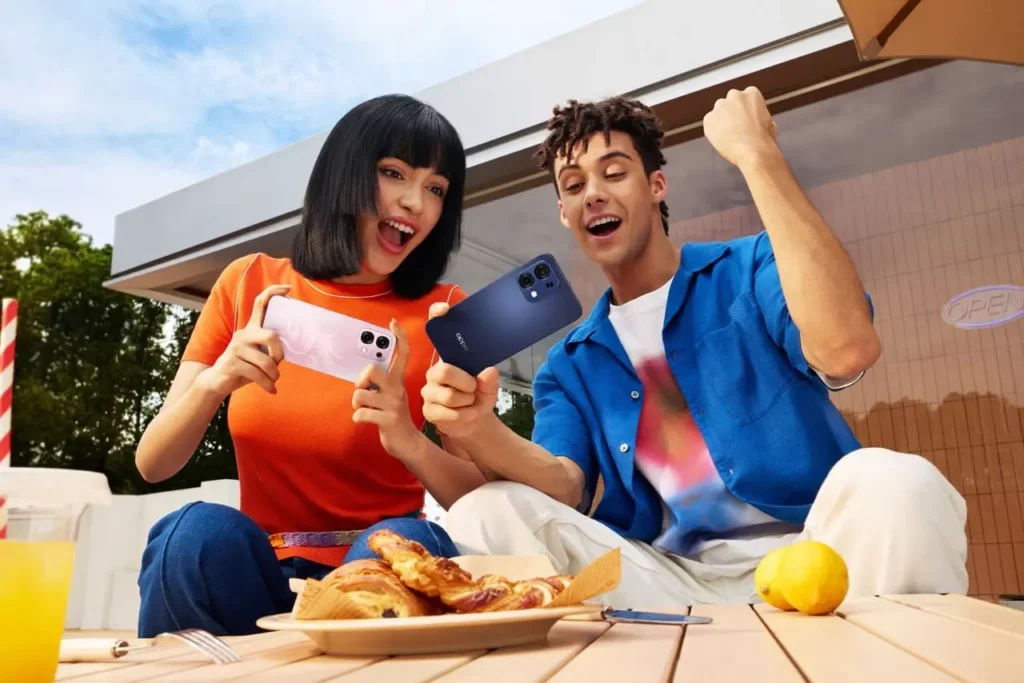 Dua pengguna muda mengekspresikan kegembiraan saat menggunakan OPPO A6 Pro yang memiliki performa mulus untuk gaming dan hiburan.