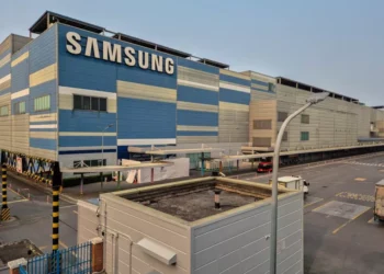 Gedung pabrik dan fasilitas besar Samsung dengan logo raksasa berwarna biru, melambangkan basis produksi global.