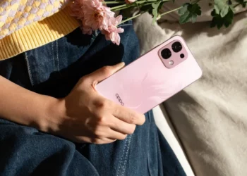 Seorang wanita memegang OPPO A6 Pro berwarna merah muda yang memiliki desain premium.