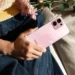 Seorang wanita memegang OPPO A6 Pro berwarna merah muda yang memiliki desain premium.