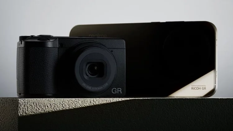Kamera Ricoh GR diletakkan di depan smartphone Realme, sebagai ilustrasi kemitraan yang membawa fitur kamera khas Ricoh ke Realme GT 8 Pro.