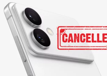 Gambar closeup bagian belakang smartphone putih dengan dua lensa kamera menonjol, dan stempel merah bertuliskan "CANCELLED" menutupi bodi ponsel. Ilustrasi ini menggambarkan pembatalan peluncuran Galaxy S26 Edge oleh Samsung.