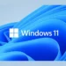 Logo Windows 11 berwarna putih di atas latar belakang wallpaper biru bergelombang yang khas, merepresentasikan sistem operasi terbaru Microsoft.