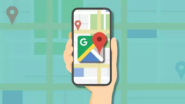 Sebuah tangan memegang smartphone yang menampilkan aplikasi Google Maps dengan peta dan ikon pin lokasi besar, berlatar belakang peta bergaya kartun.