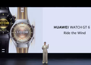 Seorang presenter wanita berdiri di depan layar besar yang menampilkan dua unit HUAWEI Watch GT 6 Pro (hitam dan krem) dan teks 'HUAWEI WATCH GT 6 Pro Ride the Wind'.