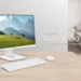 Sebuah ASUS All-in-One PC V440 berwarna putih diletakkan di atas meja kayu, menunjukkan desainnya yang estetik dan minimalis untuk ruang kerja modern.