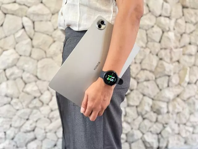 Seorang Pria memegang tablet Honor dan mengenakan Honor Watch Fit Active di pergelangan tangannya, menunjukkan integrasi perangkat dalam gaya hidup sehari-hari.