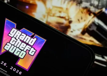 Logo Grand Theft Auto VI (GTA VI) dengan tanggal rilis 26 Mei 2026 ditampilkan di layar smartphone, terkait artikel pembahasan harga GTA VI.