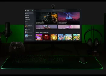Sebuah setup PC gaming dengan monitor menampilkan antarmuka Xbox Game Pass, mengilustrasikan konsep konsol Xbox baru yang mungkin berbentuk hibrida PC-konsol.