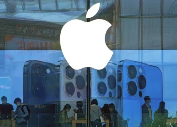 Logo Apple di jendela Apple Store sebagai ilustrasi berita Apple pindah pabrik iPhone dan Vision Pro untuk menghindari biaya perang dagang Rp17 T.