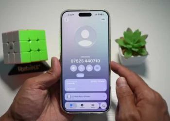 Seseorang menunjukkan cara melihat riwayat panggilan iPhone dengan mengetuk tombol "Call History" pada halaman detail kontak di iOS 26.