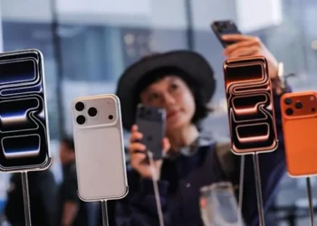 Seorang pelanggan wanita melihat jajaran iPhone 17 Pro di toko, mengilustrasikan tingginya penjualan iPhone 17 Pro.