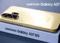 Ponsel Samsung Galaxy A37 5G berwarna emas di atas kotak kemasan yang juga bertuliskan nama produk.