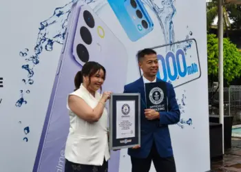 Ilustrasi smartphone Realme C85 yang terendam di dalam air, menandakan ketahanan air ekstrem yang memecahkan rekor Guinness.
