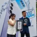 Ilustrasi smartphone Realme C85 yang terendam di dalam air, menandakan ketahanan air ekstrem yang memecahkan rekor Guinness.