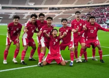 Live Streaming Indonesia U17! Sekelompok pemain Timnas U-17 Indonesia berseragam merah merayakan gol bersama dengan ekspresi kegembiraan yang meluap di lapangan stadion.