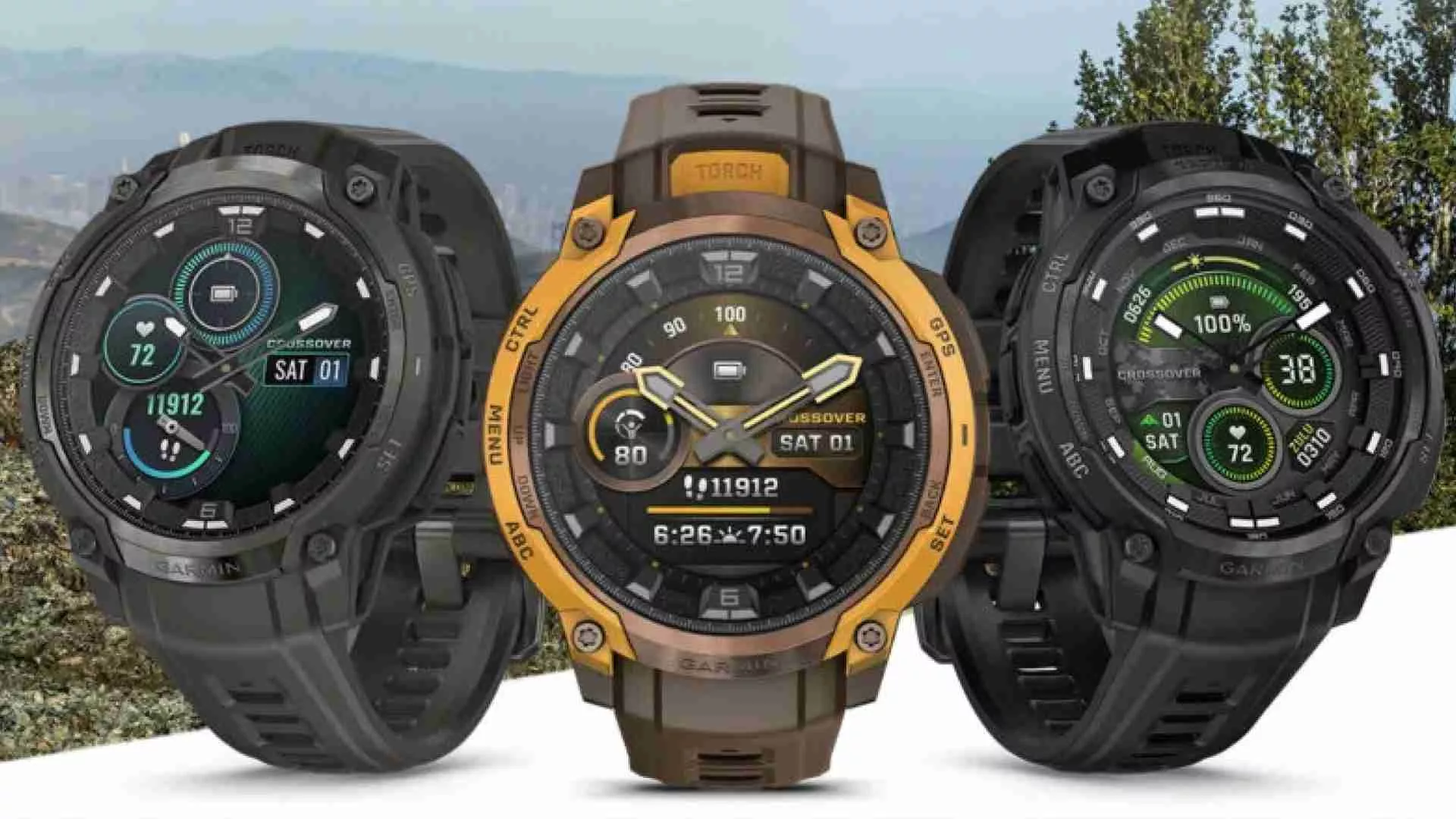 Tiga varian jam tangan Garmin Instinct Crossover AMOLED dengan warna berbeda (hitam, coklat/kuning, hitam/hijau) di latar belakang pegunungan yang kabur.