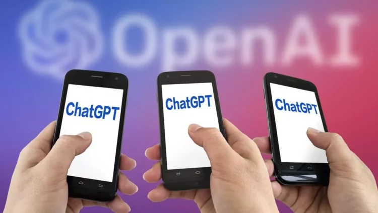 Tiga tangan memegang ponsel dengan tampilan aplikasi ChatGPT, di latar belakang buram logo OpenAI berwarna merah dan biru.