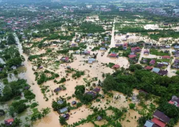 Foto udara kondisi pasca bencana banjir atau longsor di Sumatera, menunjukkan rumah dan area yang terendam air atau lumpur.