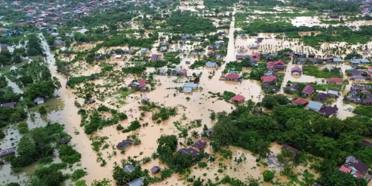 Foto udara kondisi pasca bencana banjir atau longsor di Sumatera, menunjukkan rumah dan area yang terendam air atau lumpur.