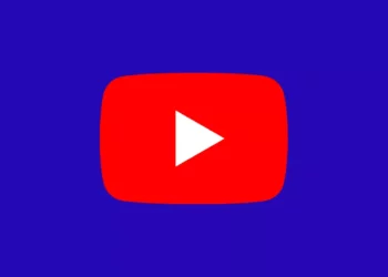 Logo play button merah ikonik YouTube di tengah latar belakang berwarna biru tua.