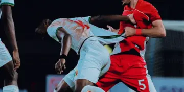 Pemain Timnas Indonesia (merah) sedang berduel fisik dengan pemain Timnas Mali (putih) untuk memperebutkan bola.