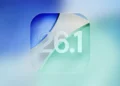 Logo visual angka "26.1" dengan desain glassmorphism di atas latar belakang blur gradasi biru dan hijau, merepresentasikan update sistem operasi iOS 26.1.