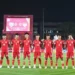 Skuad Timnas Indonesia U-17 berjejer di lapangan, mengenakan jersey merah, sebelum pertandingan melawan Brasil, dengan papan skor menunjukkan 0-0.