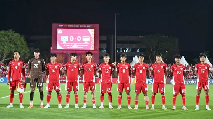 Skuad Timnas Indonesia U-17 berjejer di lapangan, mengenakan jersey merah, sebelum pertandingan melawan Brasil, dengan papan skor menunjukkan 0-0.