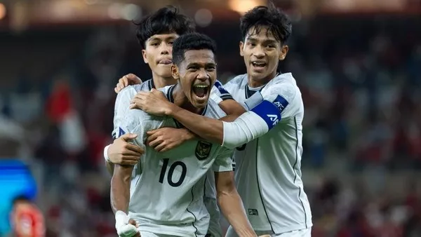 Tiga pemain Timnas Indonesia U-17 (jersey putih) merayakan gol dengan kegembiraan dan pelukan di tengah lapangan.