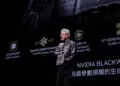 Jensen Huang, CEO NVIDIA, memegang chip AI saat presentasi NVIDIA Blackwell. Latar belakang menunjukkan slide tentang 'AI Superchip' dan 'Transformer Engine'.