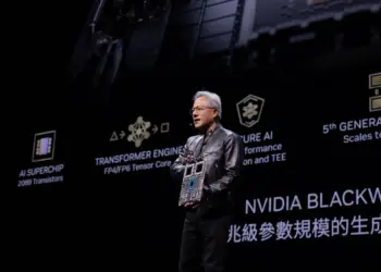 Jensen Huang, CEO NVIDIA, memegang chip AI saat presentasi NVIDIA Blackwell. Latar belakang menunjukkan slide tentang 'AI Superchip' dan 'Transformer Engine'.