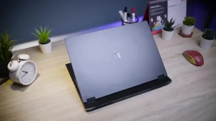 Review Acer Nitro 16S AI menampilkan desain cover sasis belakang yang minimalis dan elegan di atas meja kerja dengan setup modern.