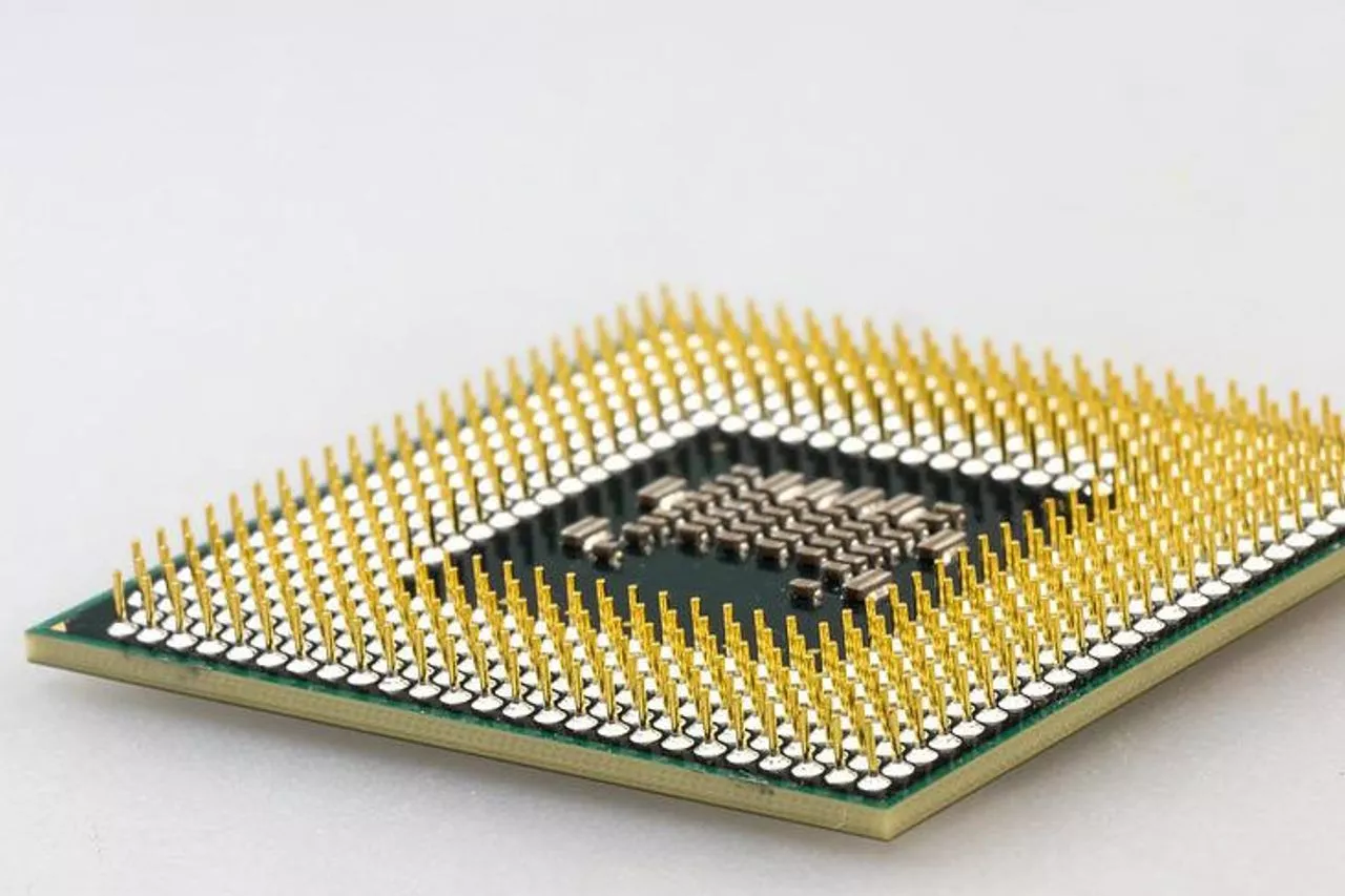 Close-up sebuah chip prosesor CPU atau GPU dengan pin-pin emas, menunjukkan komponen penting yang terpengaruh krisis pasokan.
