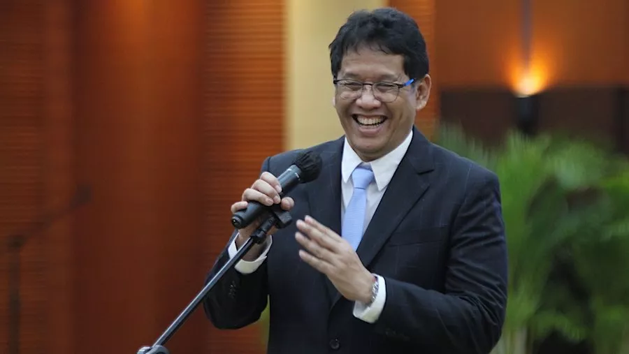 Sosok pejabat di lingkungan kerja/kantor, menyimbolkan tokoh yang terkait dengan bidang keuangan dan pemerintahan.