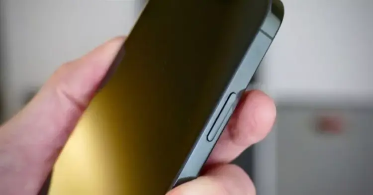 Jari pengguna menekan bagian tepi layar iPhone untuk mencoba cara menghidupkan HP tanpa tombol melalui aksesori atau koneksi kabel.